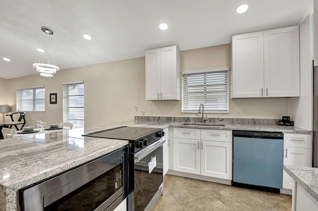 kitchen featuring appliances with stainless steel finishes, light stone counters, decorative light fixtures, sink, and white cabinetry