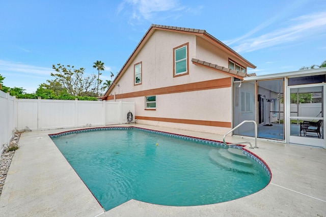 view of swimming pool with a patio area and a sunroom