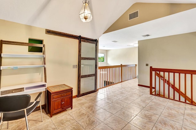 corridor featuring light tile patterned flooring, a barn door, and high vaulted ceiling