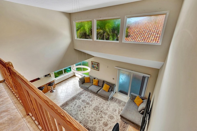 tiled living area with a towering ceiling