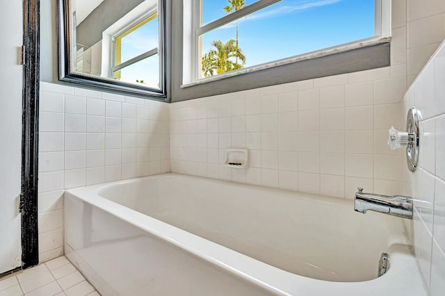 bathroom with tile walls, a bath, and tile patterned floors