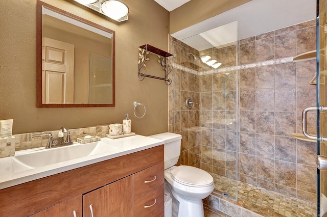 full bathroom with a stall shower, vanity, and toilet