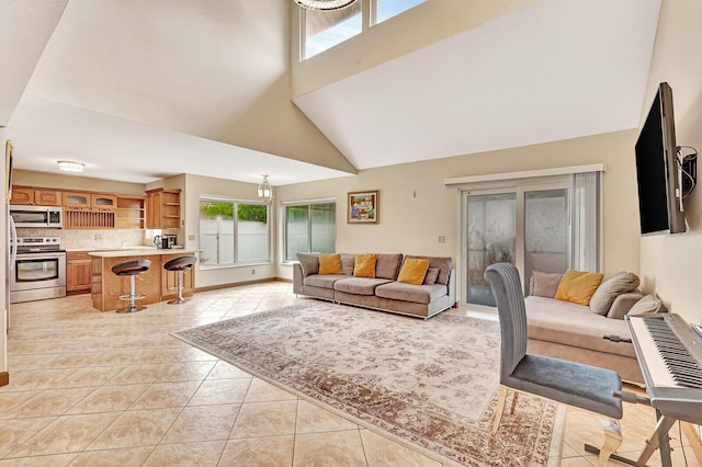 living area featuring light tile patterned floors, a high ceiling, and baseboards