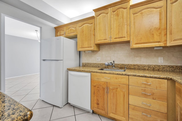 kitchen featuring tasteful backsplash, white appliances, sink, light tile patterned floors, and stone countertops