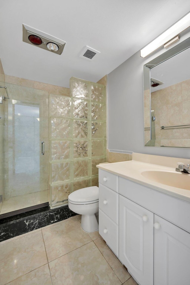 bathroom with tile patterned flooring, vanity, toilet, and a shower with shower door