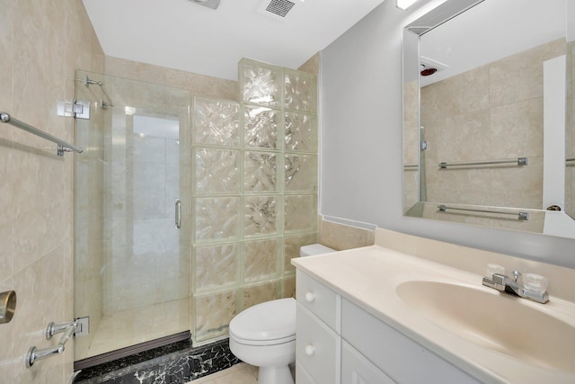 bathroom with vanity, toilet, and a shower with door