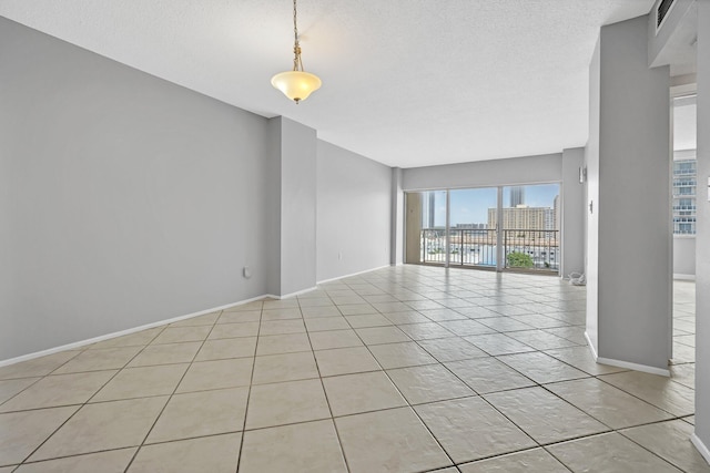 empty room featuring light tile patterned floors and a textured ceiling