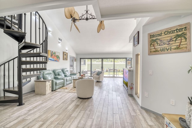 living room with light wood-type flooring, high vaulted ceiling, and a notable chandelier