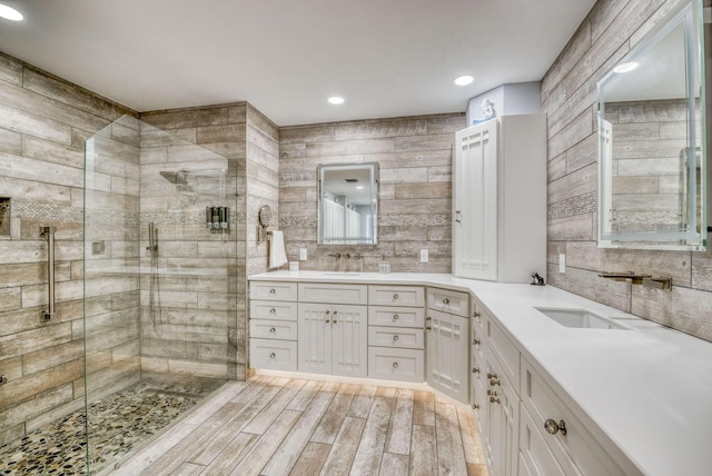 bathroom with vanity, hardwood / wood-style flooring, and a shower with door