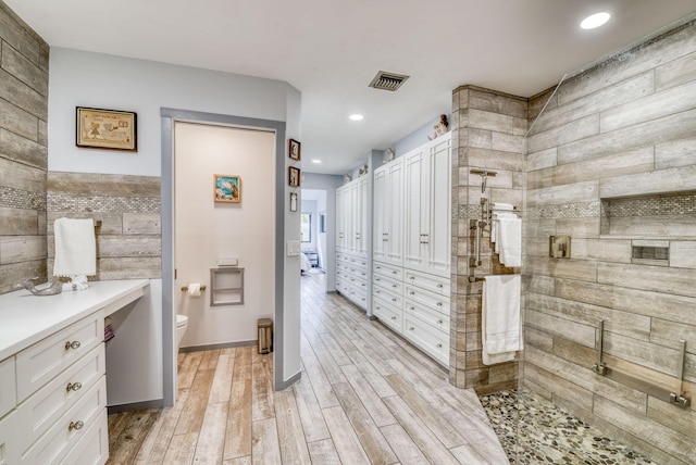 bathroom featuring walk in shower, toilet, and hardwood / wood-style flooring