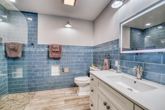 bathroom featuring hardwood / wood-style floors, vanity, toilet, and tile walls