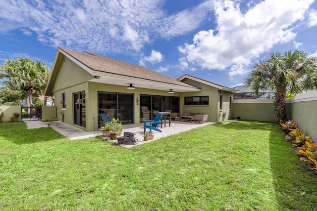 rear view of house featuring ceiling fan, a patio area, a yard, and an outdoor hangout area