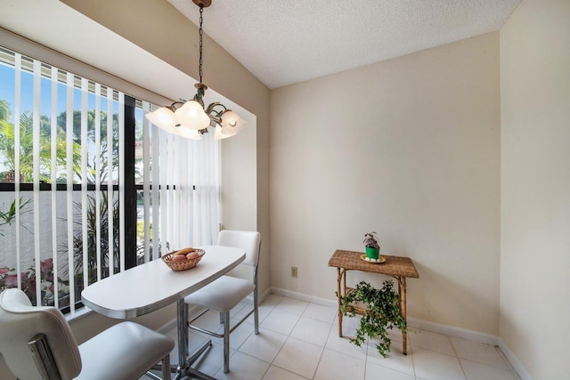 tiled dining space with a notable chandelier and a textured ceiling