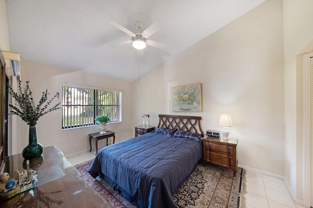 bedroom with ceiling fan, light tile patterned flooring, a textured ceiling, and vaulted ceiling