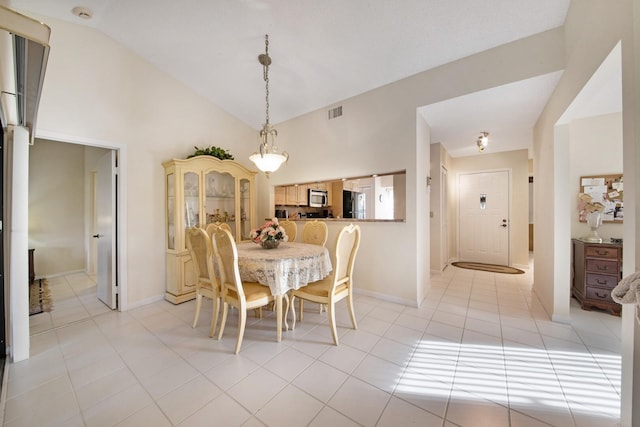 tiled dining space featuring lofted ceiling