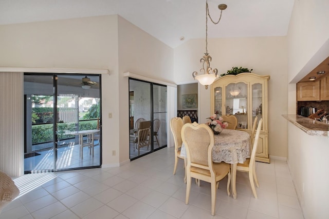 dining space featuring light tile patterned flooring and high vaulted ceiling