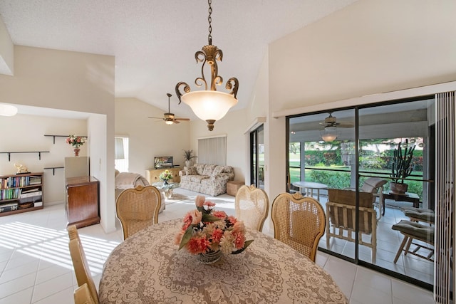 dining room with light tile patterned floors, a textured ceiling, and high vaulted ceiling