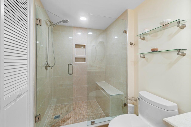 bathroom with a shower with door and toilet