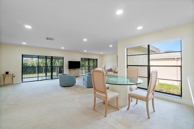 dining room featuring light carpet and a healthy amount of sunlight