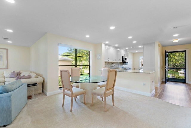 dining space with light wood-type flooring and sink