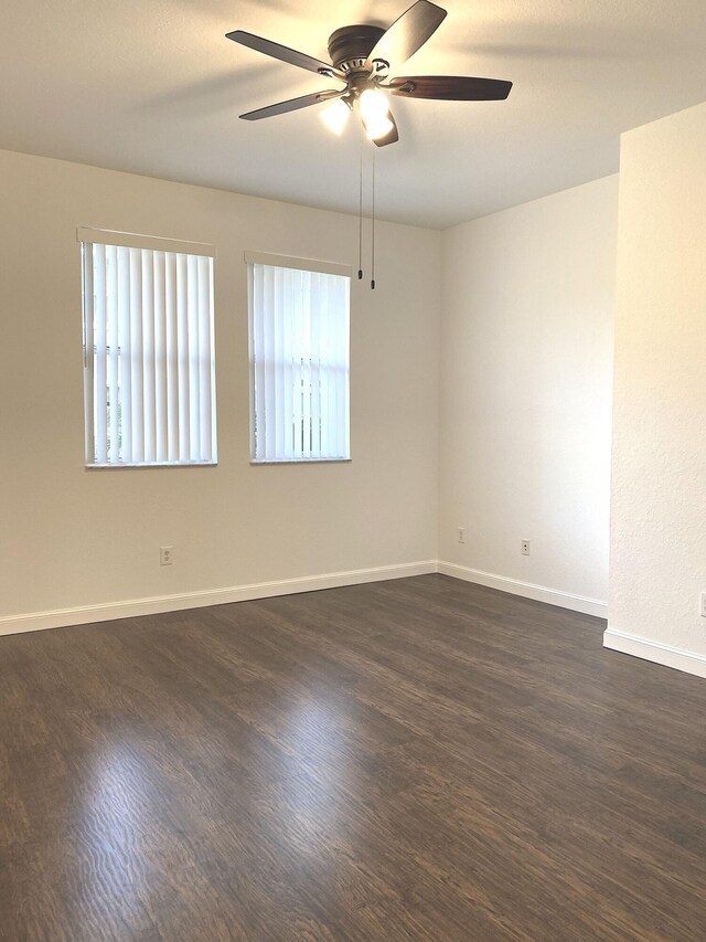 empty room with dark hardwood / wood-style floors and ceiling fan