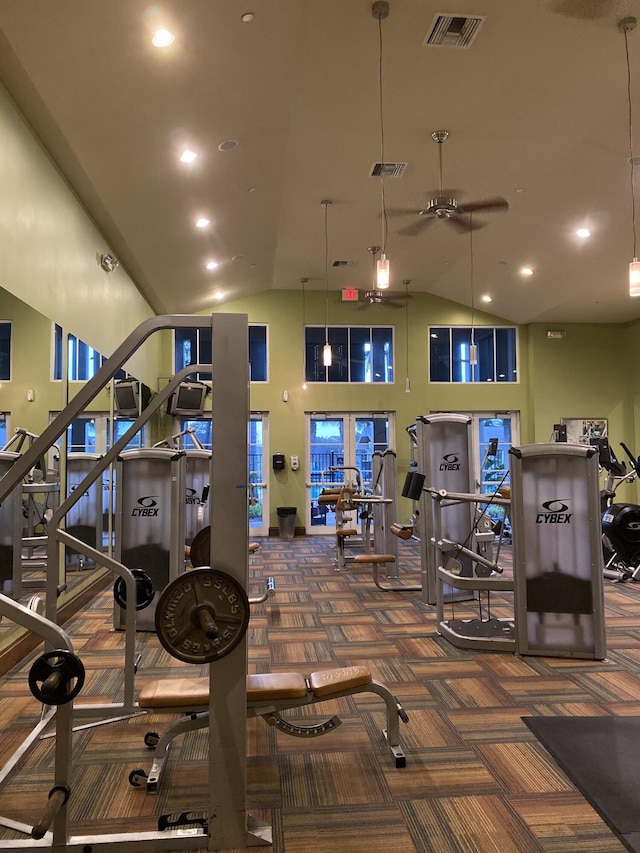 exercise room with ceiling fan, dark carpet, and high vaulted ceiling