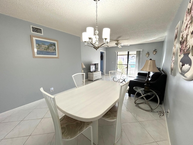 tiled dining space featuring a textured ceiling and ceiling fan with notable chandelier