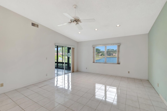 spare room featuring light tile patterned floors, vaulted ceiling, and ceiling fan