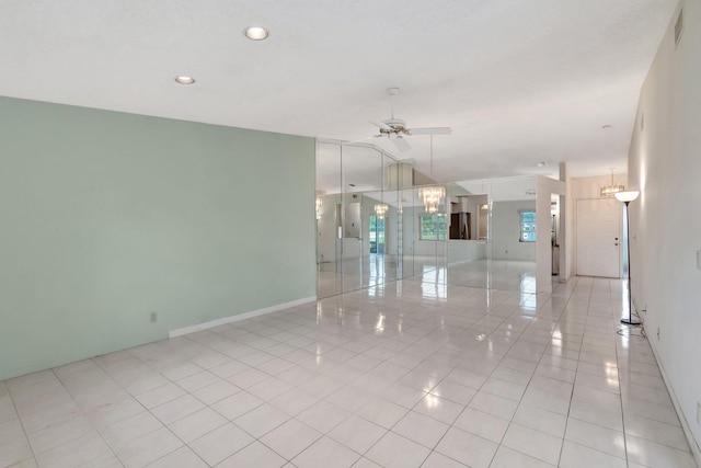 spare room with ceiling fan and light tile patterned flooring