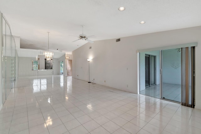 tiled spare room featuring lofted ceiling and ceiling fan with notable chandelier