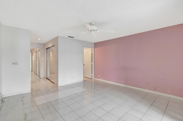 tiled spare room featuring ceiling fan