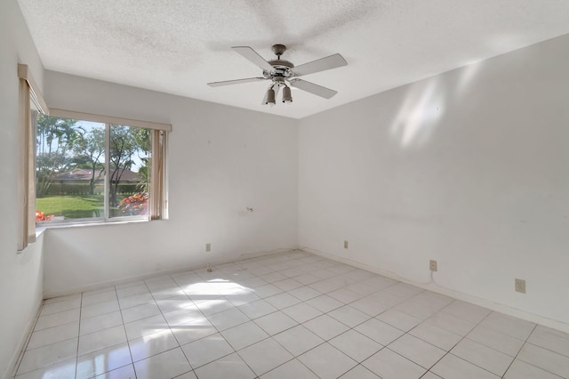 tiled spare room with a textured ceiling and ceiling fan