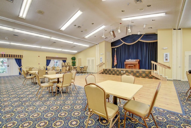 dining space with a textured ceiling and vaulted ceiling