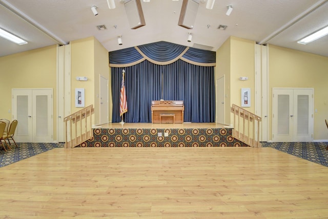 interior space with french doors, hardwood / wood-style floors, and lofted ceiling