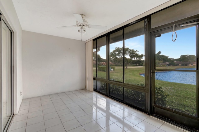 unfurnished sunroom with ceiling fan, a water view, and a wealth of natural light