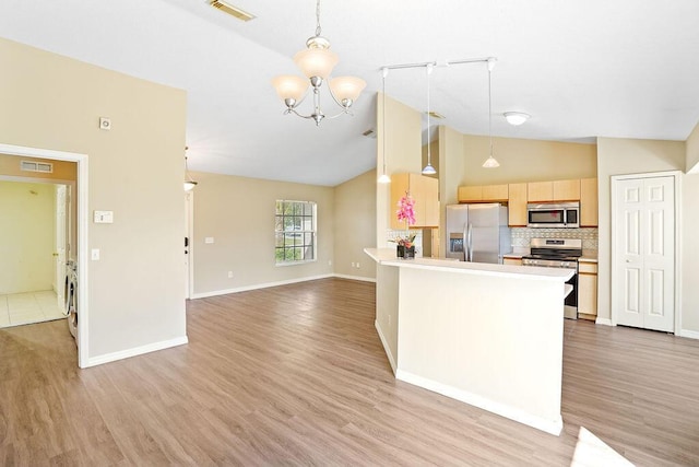 kitchen featuring light brown cabinetry, light hardwood / wood-style flooring, hanging light fixtures, and appliances with stainless steel finishes