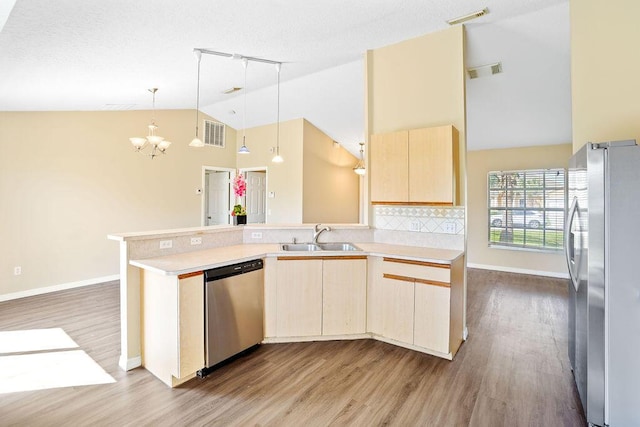 kitchen featuring light brown cabinetry, high vaulted ceiling, stainless steel appliances, and sink