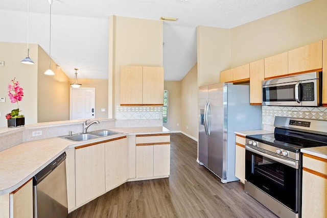 kitchen featuring pendant lighting, hardwood / wood-style floors, light brown cabinets, sink, and appliances with stainless steel finishes