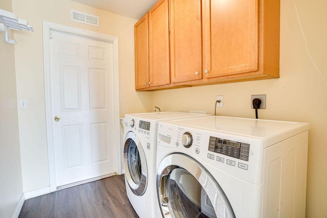 laundry area featuring washer and clothes dryer, dark hardwood / wood-style flooring, cabinets, and a textured ceiling