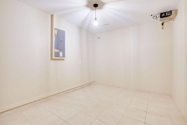 tiled empty room featuring electric panel