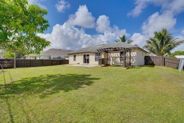 back of house with a lawn and a patio