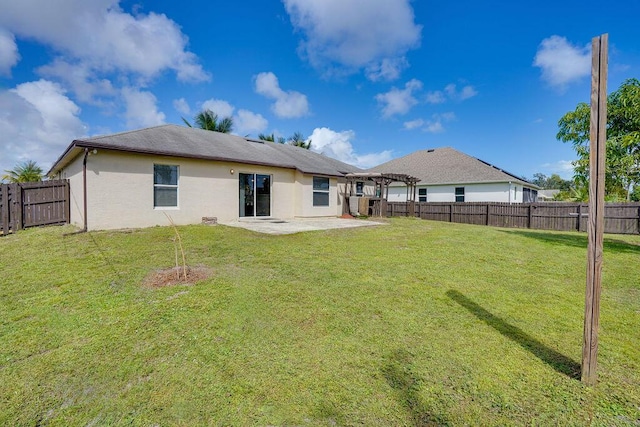 back of house featuring a lawn and a patio