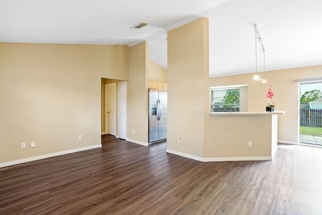 unfurnished living room featuring plenty of natural light, dark hardwood / wood-style floors, and high vaulted ceiling