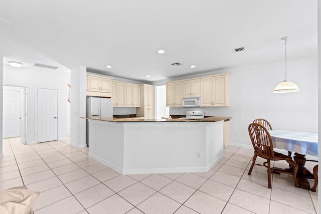 kitchen with cream cabinetry, white appliances, hanging light fixtures, and light tile patterned flooring