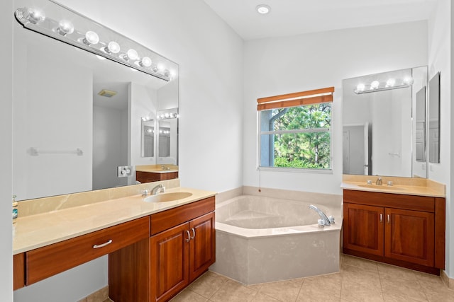 bathroom featuring tile patterned flooring, vanity, and tiled bath