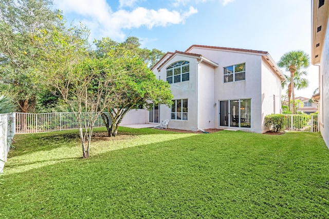 back of house featuring a lawn