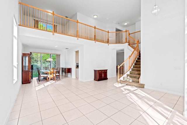 interior space with a towering ceiling and light tile patterned flooring