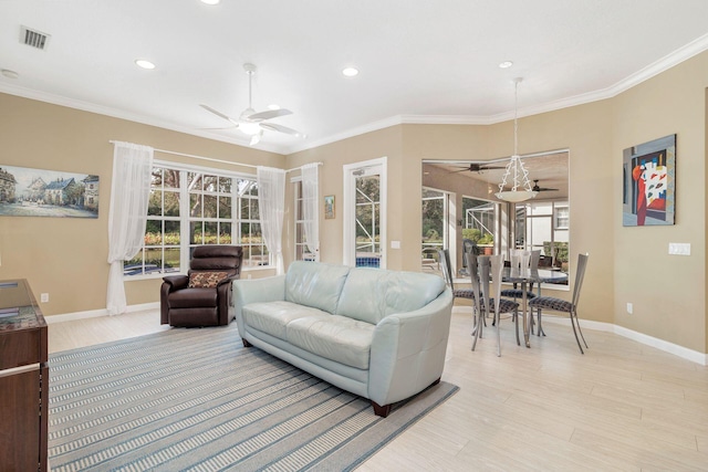 living room with light wood-type flooring, ceiling fan, and ornamental molding