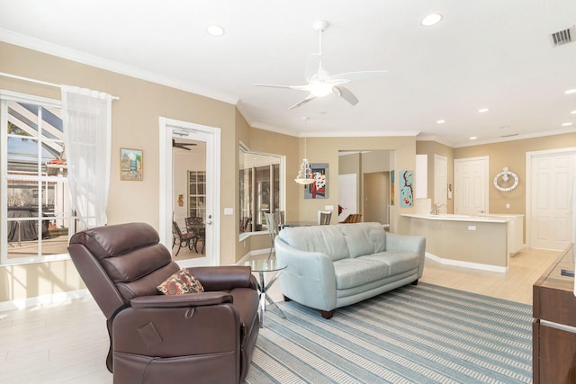 living room with ceiling fan, light wood-type flooring, and ornamental molding