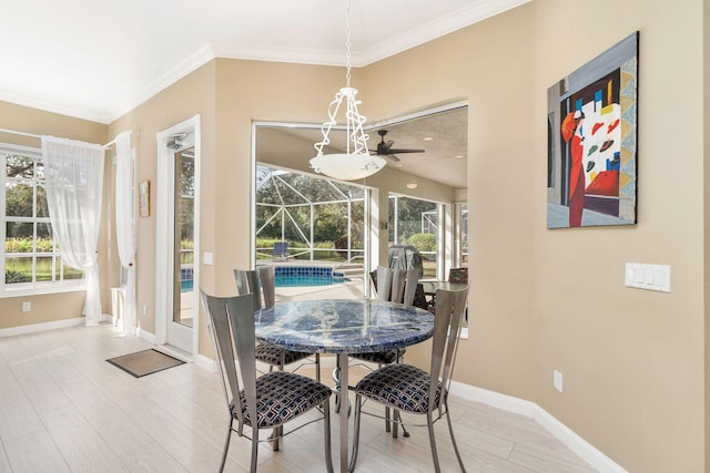 dining area with light hardwood / wood-style floors, a wealth of natural light, and ornamental molding